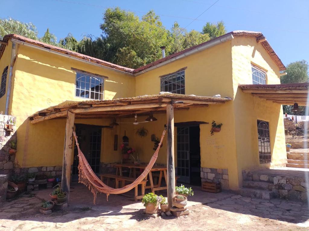 una casa amarilla con una hamaca delante en La Amarilla, casa con hermosa vista, en Tilcara