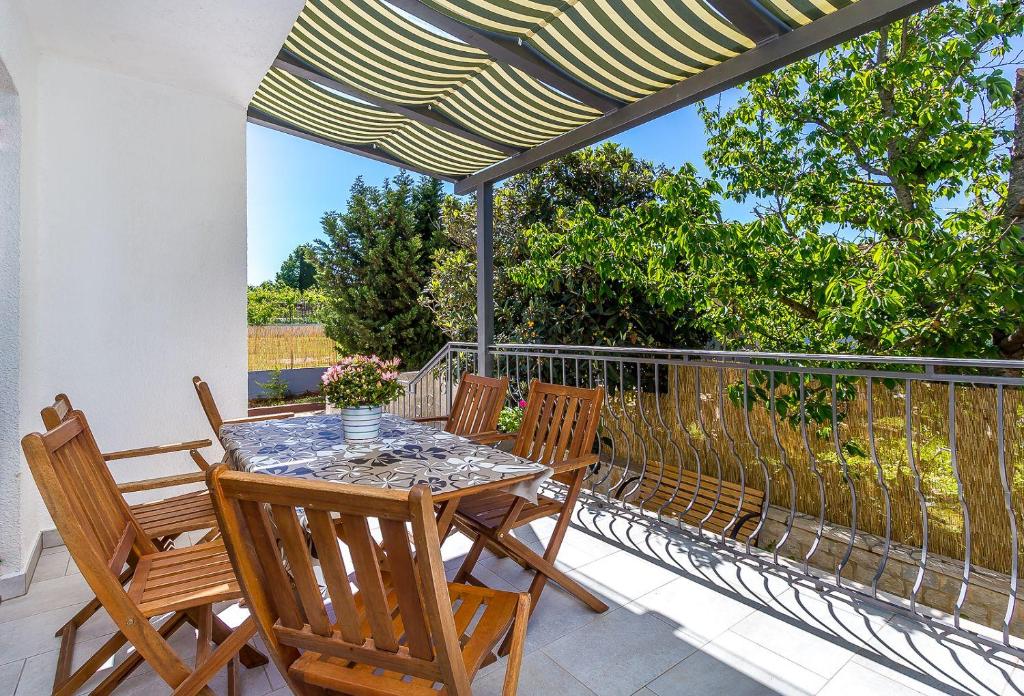 d'une table et de chaises sur un balcon avec un parasol dans l'établissement Neu renovierte Ferienwohnung mit Klima, WLAN, Terrasse und Grill, à Pula