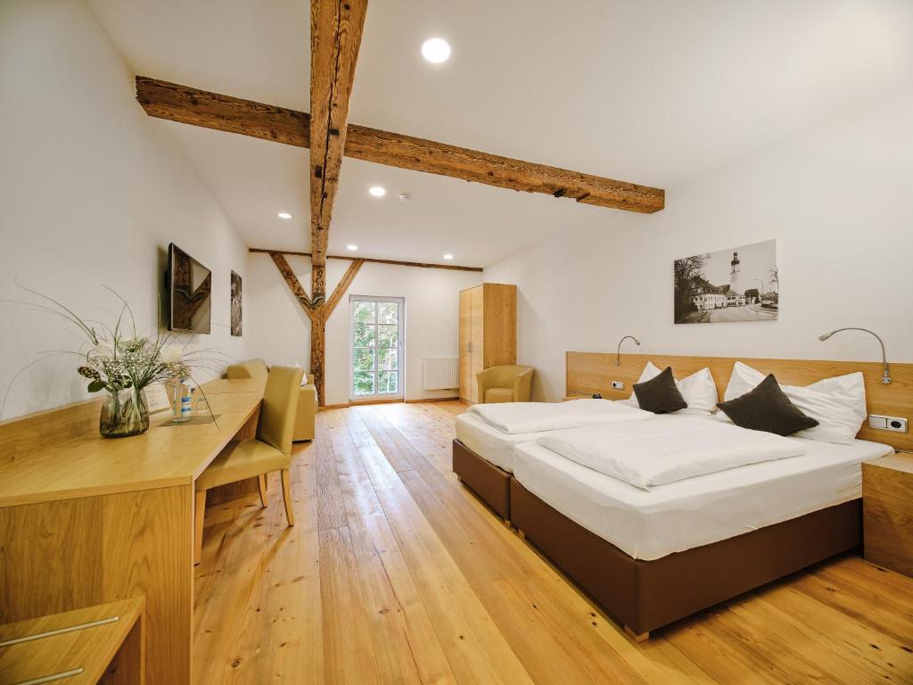 um quarto com uma cama grande e uma secretária em Hofwirthotel em Sankt Martin im Innkreis