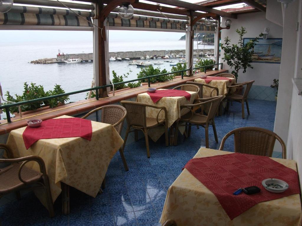 una fila de mesas y sillas en un restaurante en Holidays Baia D'Amalfi, en Amalfi