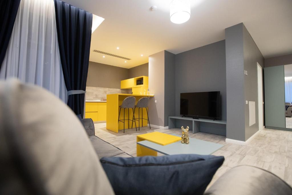 ein Wohnzimmer mit einem Sofa und einem TV in der Unterkunft Omnia Apartments in Iaşi