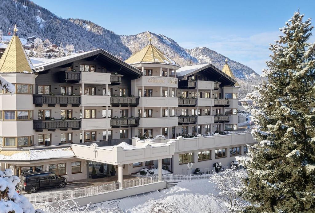 a hotel in the mountains with snow on the ground at Gardena Grödnerhof - Hotel & Spa in Ortisei