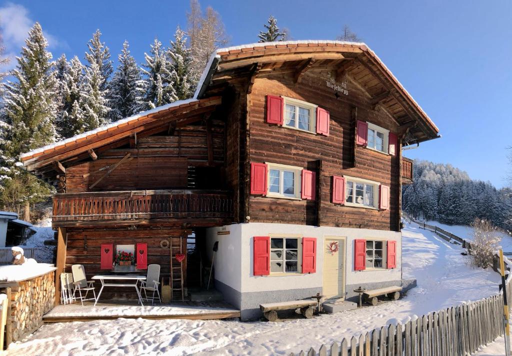 een blokhut in de sneeuw met een tafel bij Sonniges Chalet Arosa für 6 Pers alleinstehend mit traumhaftem Bergpanorama in Langwies