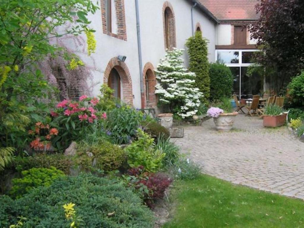 een tuin voor een huis met bloemen bij Le Corrigot in Pierry