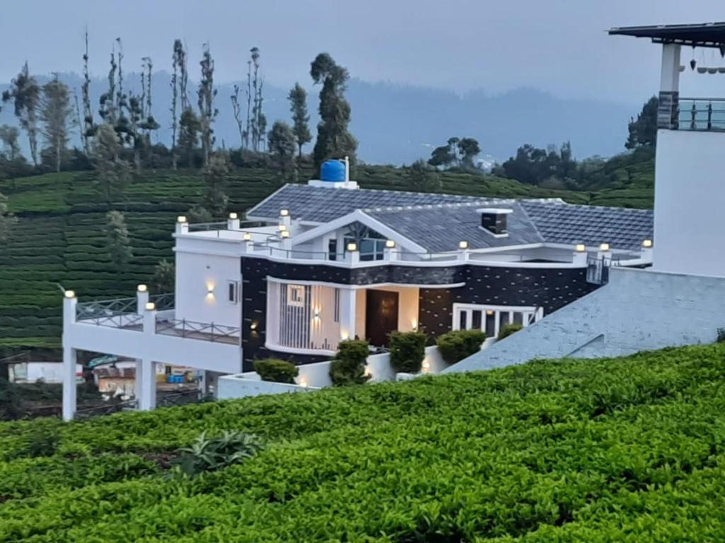 una casa en la cima de una colina con luces en Orchard Valley View Home Stay, en Ooty