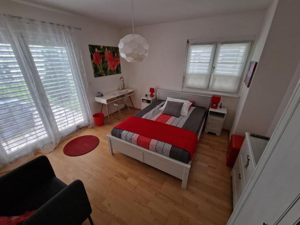 - une chambre avec un lit et une couverture rouge dans l'établissement BnB "Les Coquelicots", à Mies