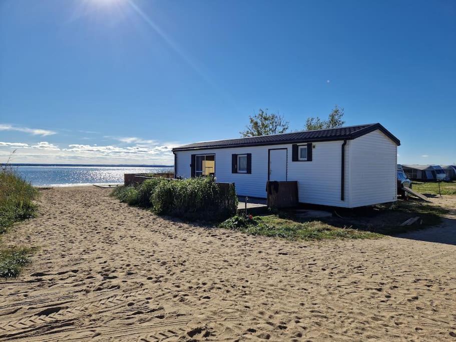 a small shack on a beach next to the water at Kite House Chałupy in Władysławowo