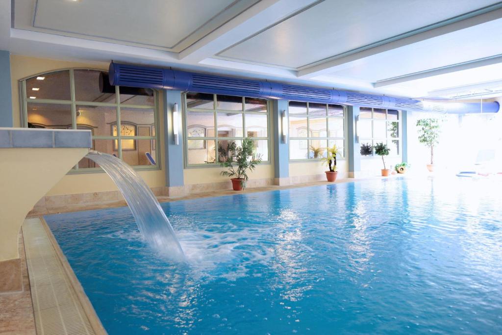 - une piscine avec une fontaine dans un bâtiment dans l'établissement Ringhotel Fährhaus, à Bad Bevensen