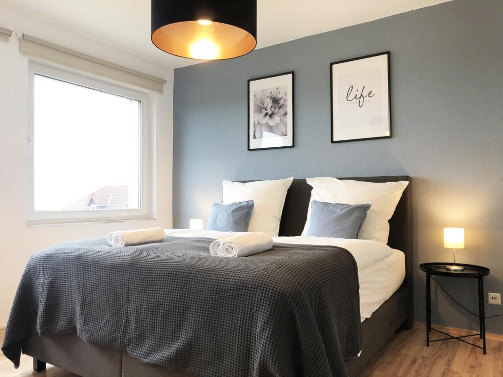 - une chambre avec un lit et 2 serviettes dans l'établissement LIME HOMES: Balkon, Küche, Netflix, à Barsinghausen