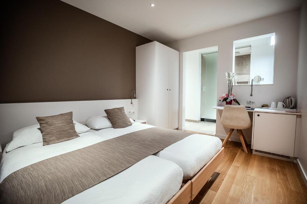 een slaapkamer met een groot bed en een keuken bij Hôtel Elite in Sion