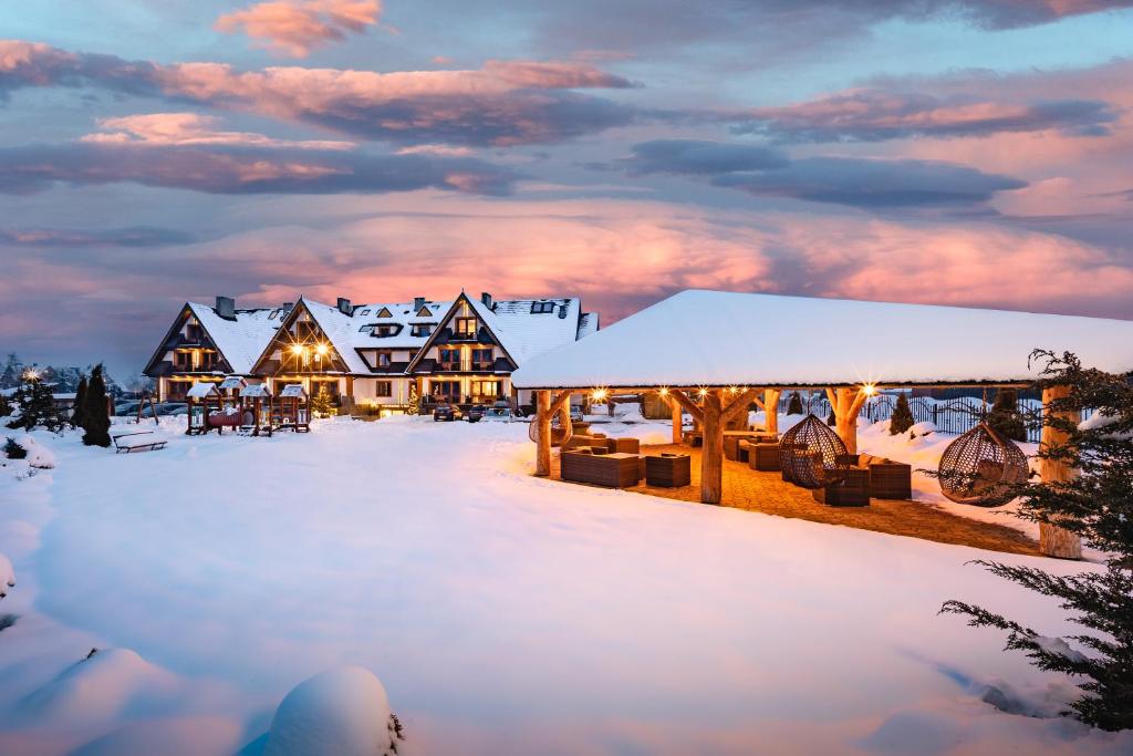 um resort coberto de neve ao anoitecer em Aparthotel Diamond SPA Family em Białka Tatrzanska