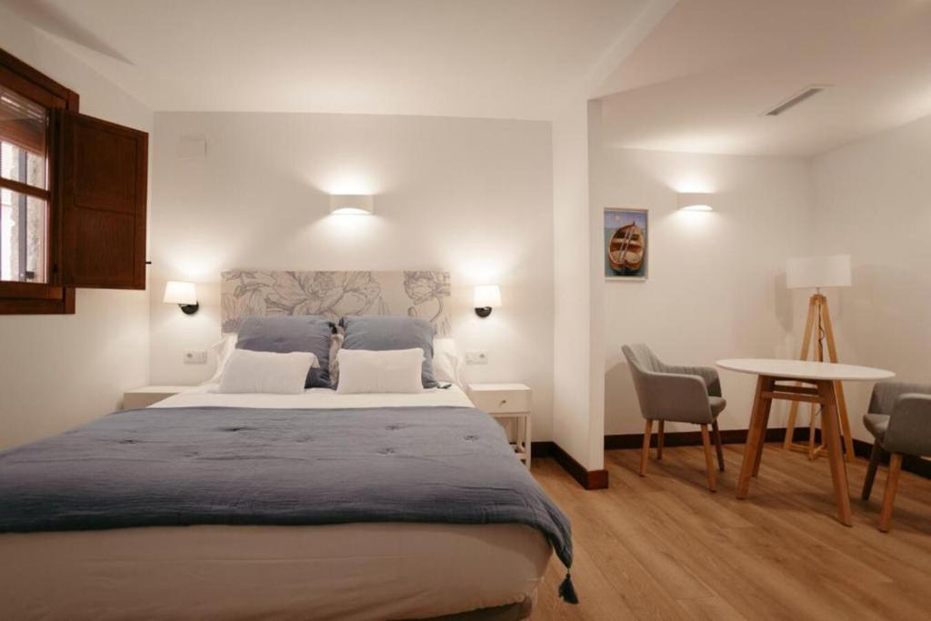 - une chambre avec un grand lit et une table dans l'établissement La Plaza Hostal, à Peñíscola