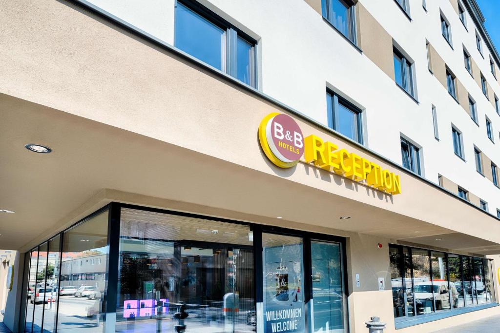 维也纳B&B Hotel Wien-Stadthalle的建筑物前面的商店,上面有标志