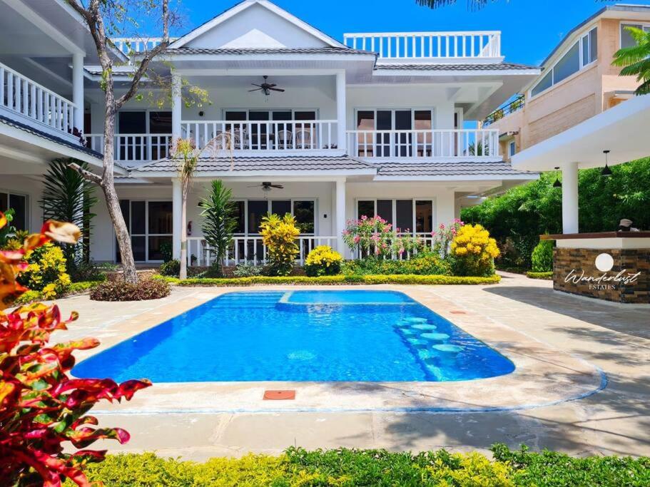 a house with a swimming pool in front of a house at Fiorella Beach House, Diani Beach in Diani Beach