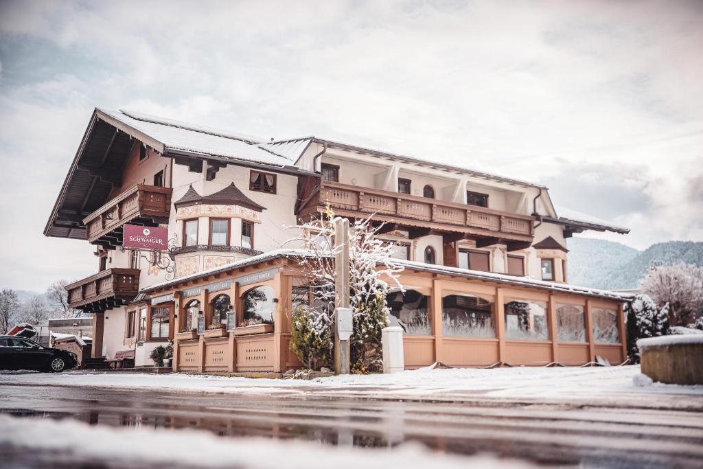 un gran edificio con nieve en el suelo en Schwaiger, en Breitenbach am Inn