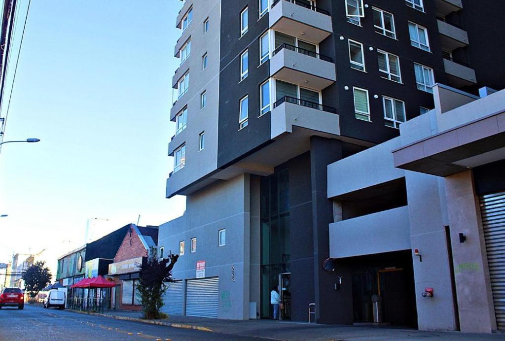 een hoog gebouw aan de kant van een straat bij Apart Hotel Bauerle & Apartamentos in Temuco