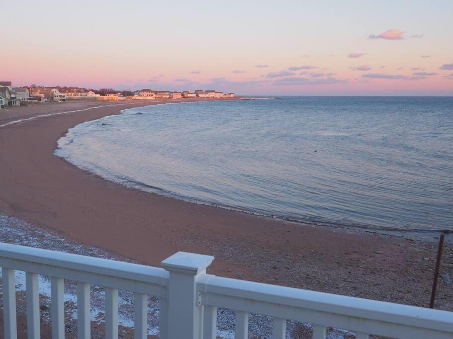 una spiaggia con recinzione bianca e l'oceano di Casa al Mare Beachfront Retreat King Bed Near Yale a East Haven