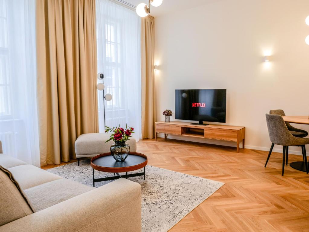 ein Wohnzimmer mit einem Sofa und einem TV in der Unterkunft Laurinska 1 Apartments in Bratislava