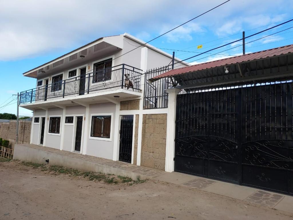 Cette maison blanche dispose d'un balcon et d'un portail. dans l'établissement Wally’s Place, à Estelí