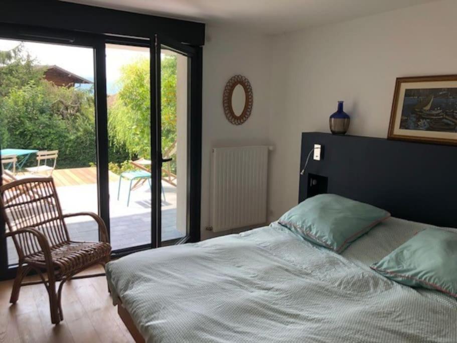 - une chambre avec un lit, une chaise et une terrasse dans l'établissement Maison de vacances 220m2 vue Lac et Château, à Menthon-Saint-Bernard