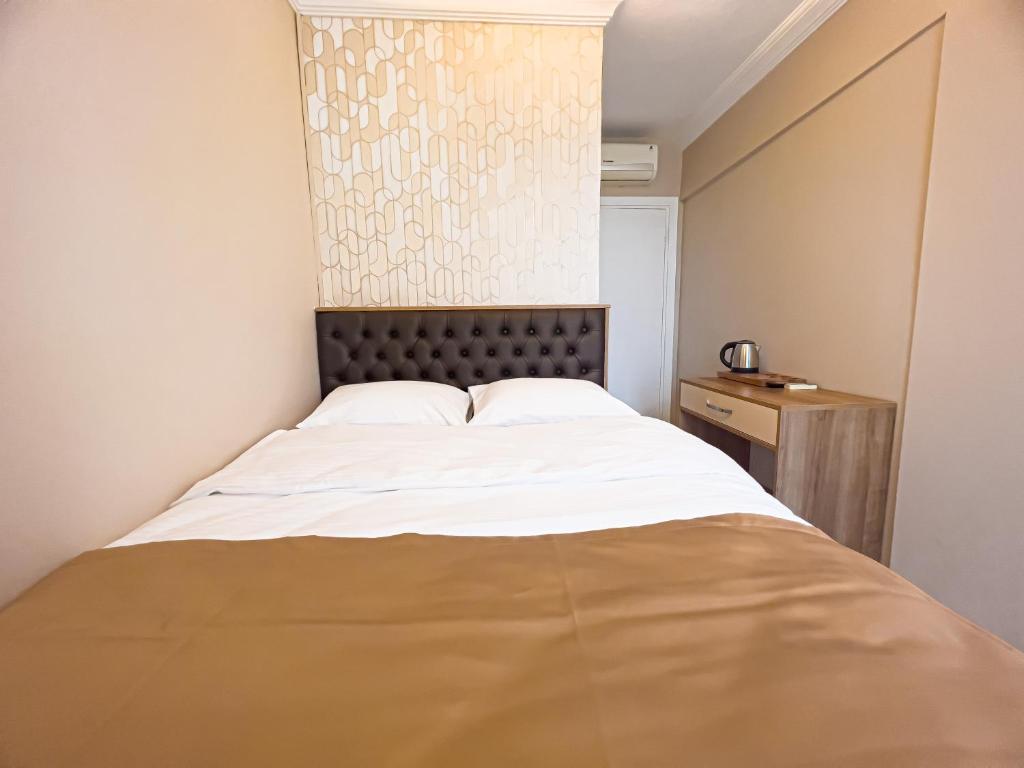 a bedroom with a large bed with a headboard at Helen Inn in Izmir