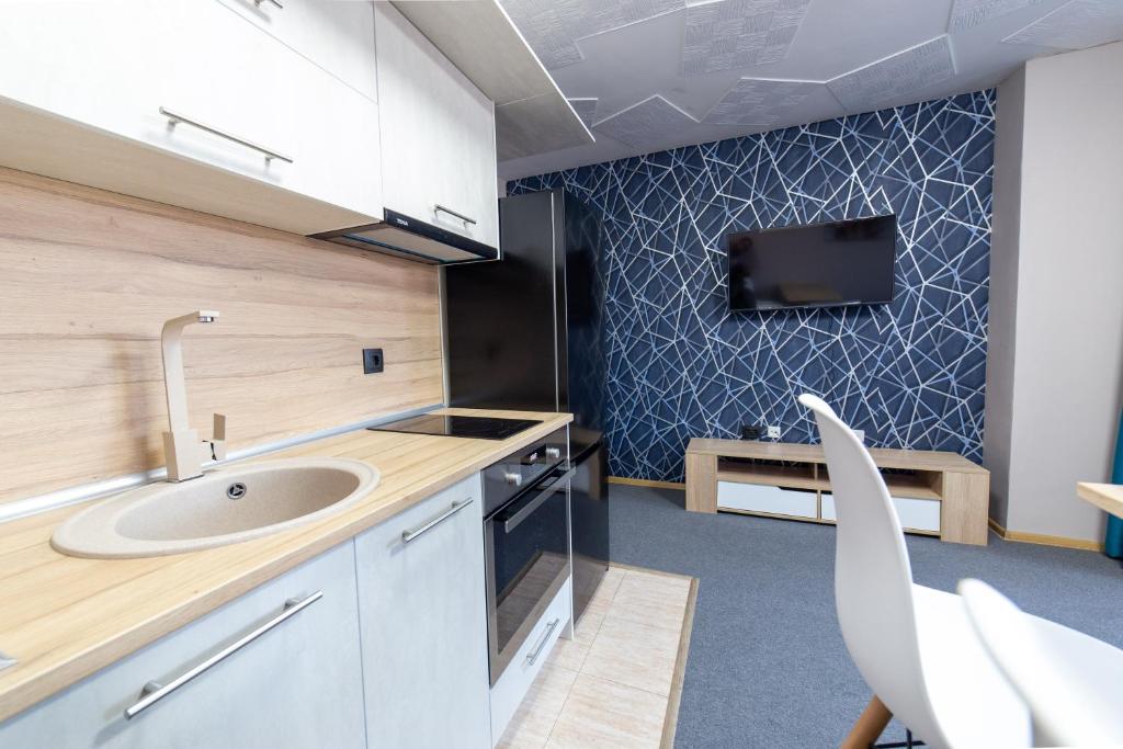 een keuken met een wastafel en een tv aan de muur bij Luxury Studio Apartment - Varna Residens in Varna