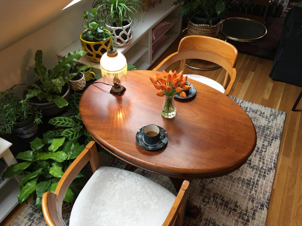 une table en bois avec un vase de fleurs. dans l'établissement Urban Oasis in Hope Village, à Providence