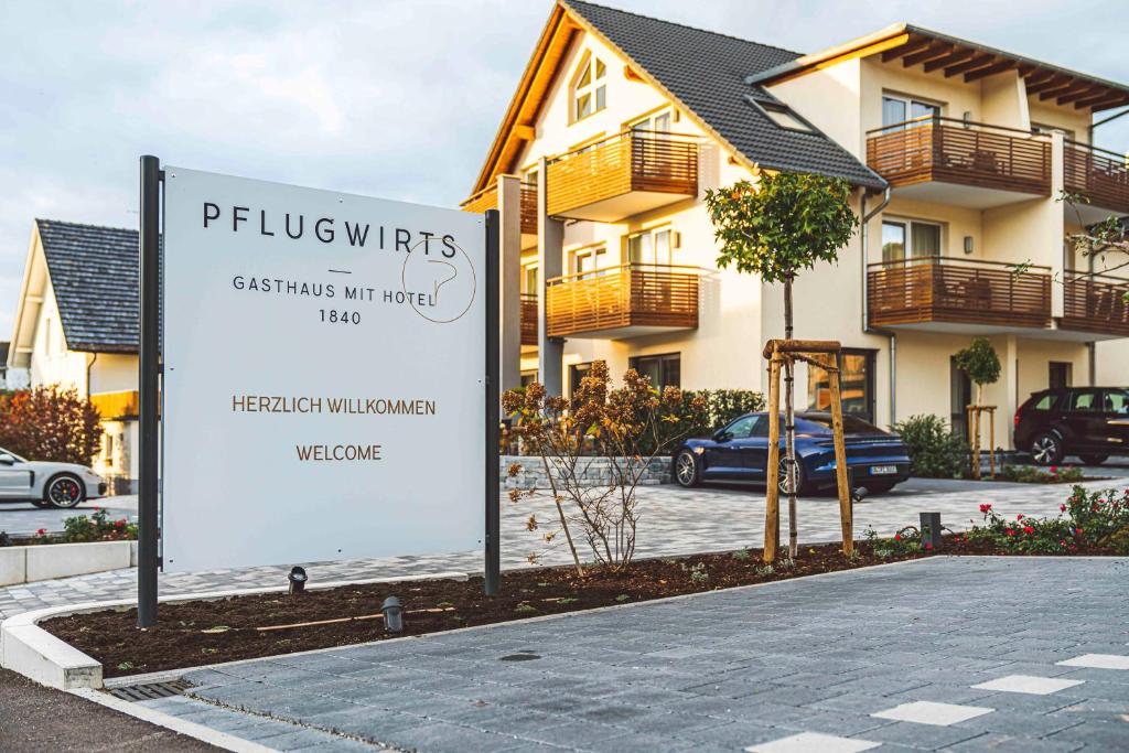 un cartello di fronte a una casa con un edificio di Pflugwirts Hotel und Gasthaus a Oberkirch