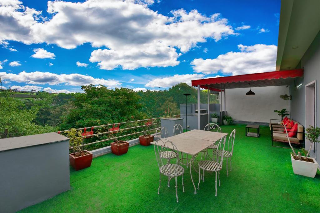 a patio with a table and chairs on a balcony at Divine Inn Couple Friendly Hotel near Sector 51 Metro Station in Noida