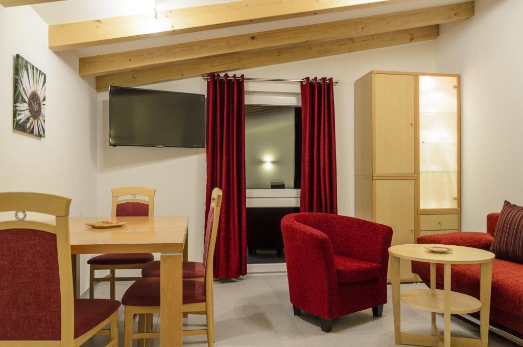 a living room with red chairs and a table at Ferienwohnung Radebeul Gerlach in Radebeul