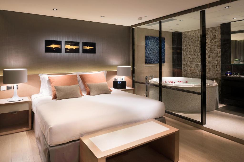 una camera con un letto e una vasca di Nina Hotel Island South a Hong Kong