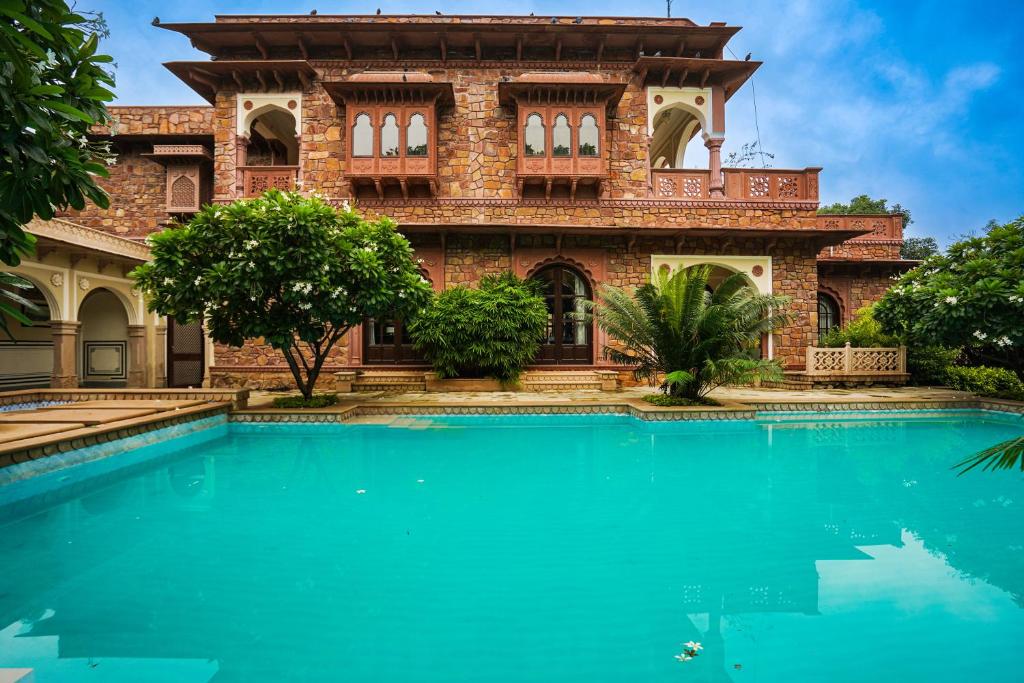 una casa con piscina frente a ella en Khas Bagh, en Jaipur