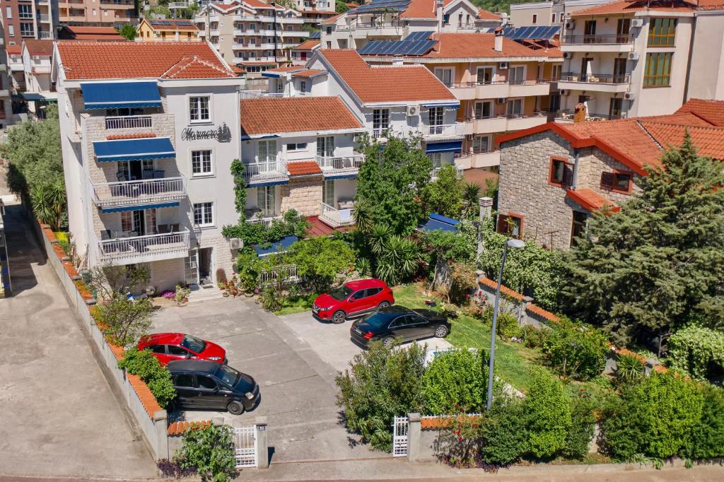 dois carros estacionados num parque de estacionamento numa cidade em Marinero Apartments em Budva