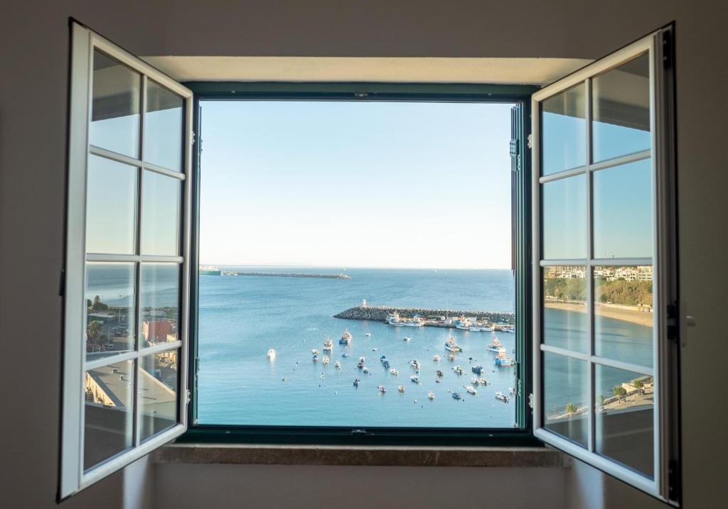 ventana con vistas a la playa y al océano en Manas Coliving, en Sines