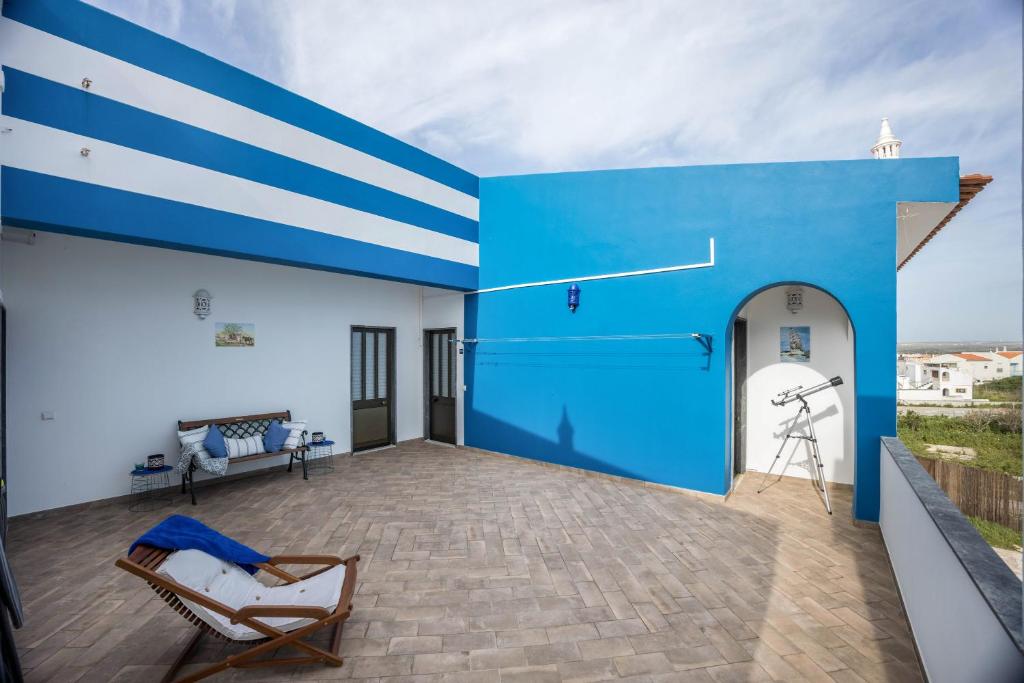 a blue and white building with two chairs on a patio at Cabo de Sagres -2 bedroom apartment in Sagres