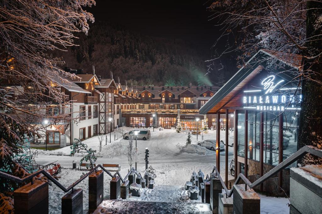 eine Skihütte im Schnee in der Nacht in der Unterkunft Szczawnica Park Resort & Spa in Szczawnica