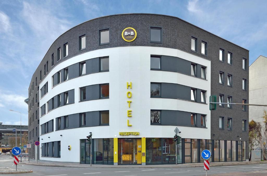 um grande edifício branco com um sinal amarelo em B&B HOTEL Erfurt-Hbf em Erfurt