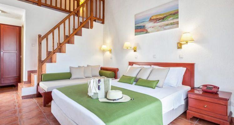 a bedroom with two beds and a staircase at Rigas Hotel Skopelos in Skopelos Town