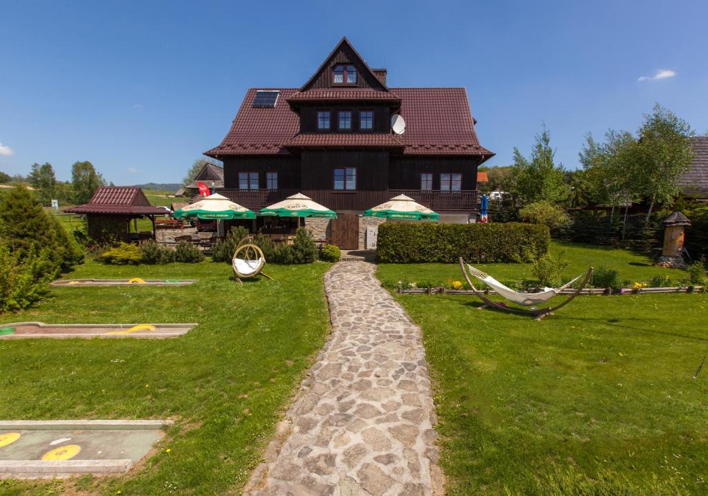 a house with a stone path in front of a yard at Willa Jordanówka in Czorsztyn