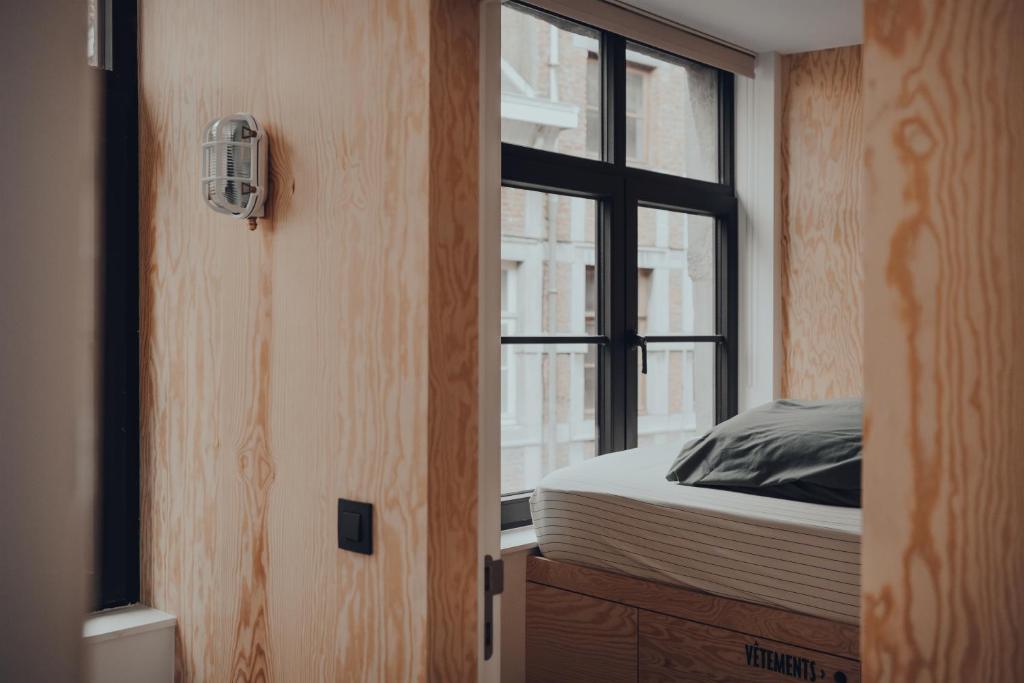 een slaapkamer met een bed en een raam bij Cabane Urbaine 1 - centre in Namen