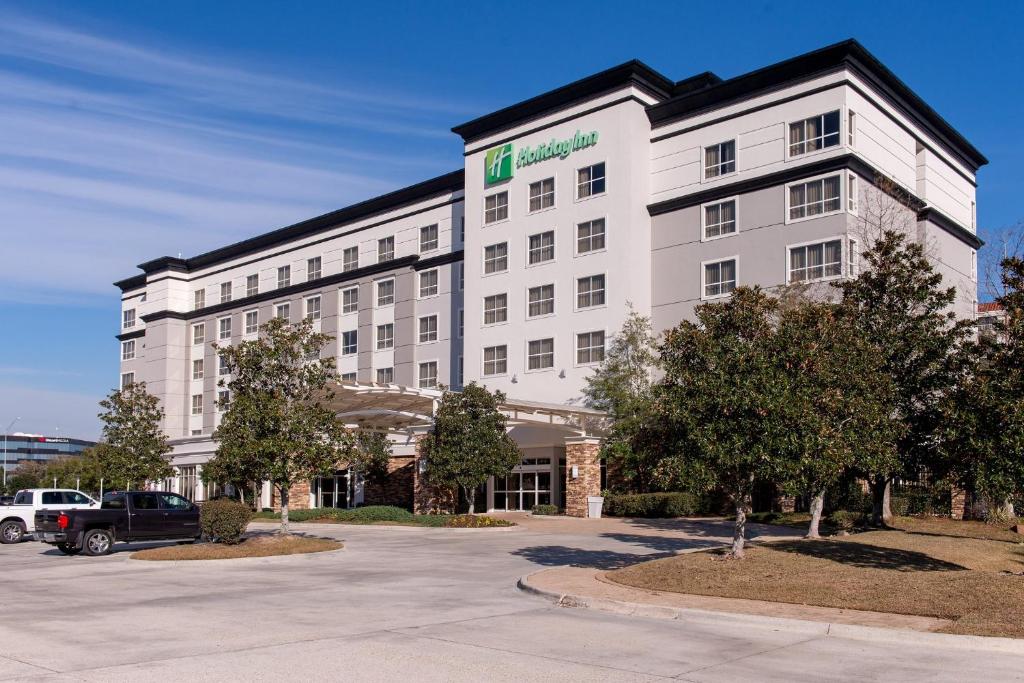 un edificio alberghiero con un'auto parcheggiata in un parcheggio di Holiday Inn Baton Rouge College Drive I-10, an IHG Hotel a Baton Rouge