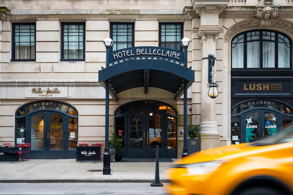 een gele taxi die langs een hotelgebouw rijdt bij Hotel Belleclaire Central Park in New York