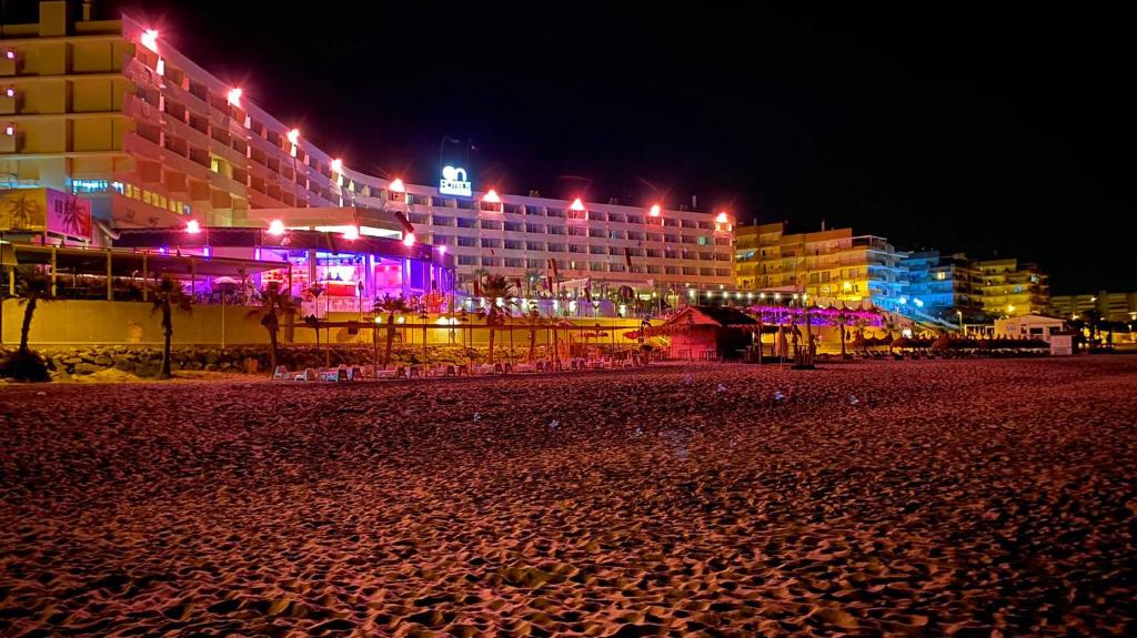 - une plage de nuit avec des bâtiments et des lumières dans l'établissement Paraíso!, à Matalascañas