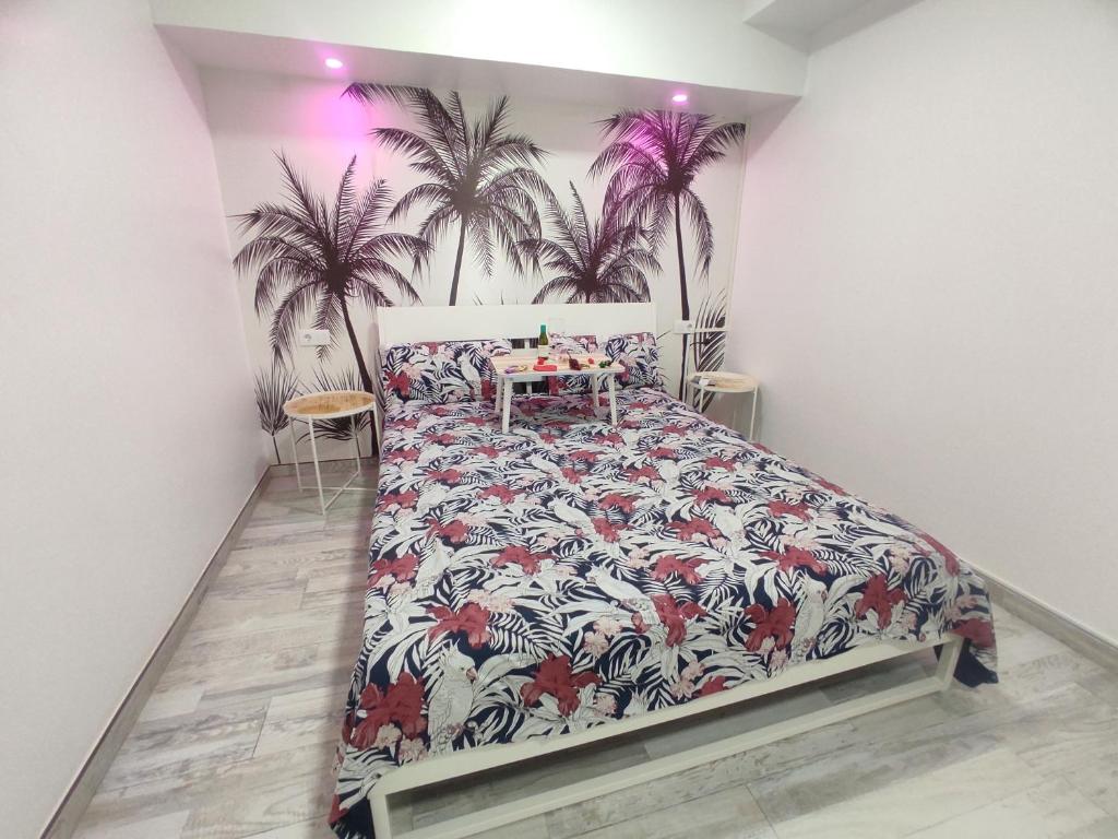 um quarto com uma cama com um mural de palmeiras em Sweet Apt Charco by flamingo house em Arrecife