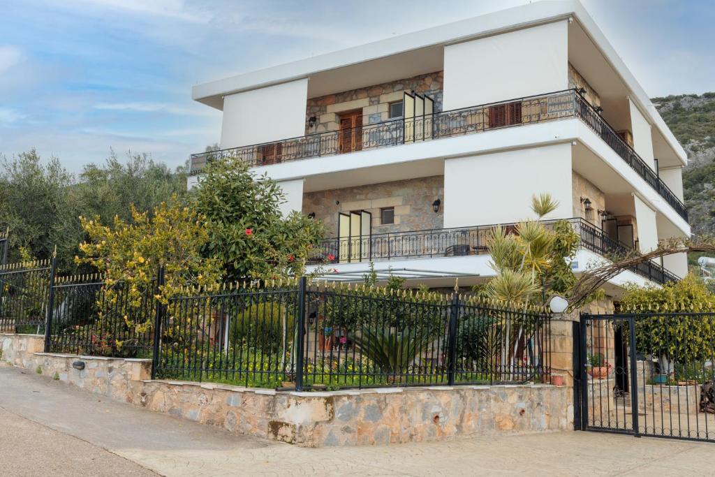 un edificio blanco con una valla delante en Paradeisos, en Kardhamili