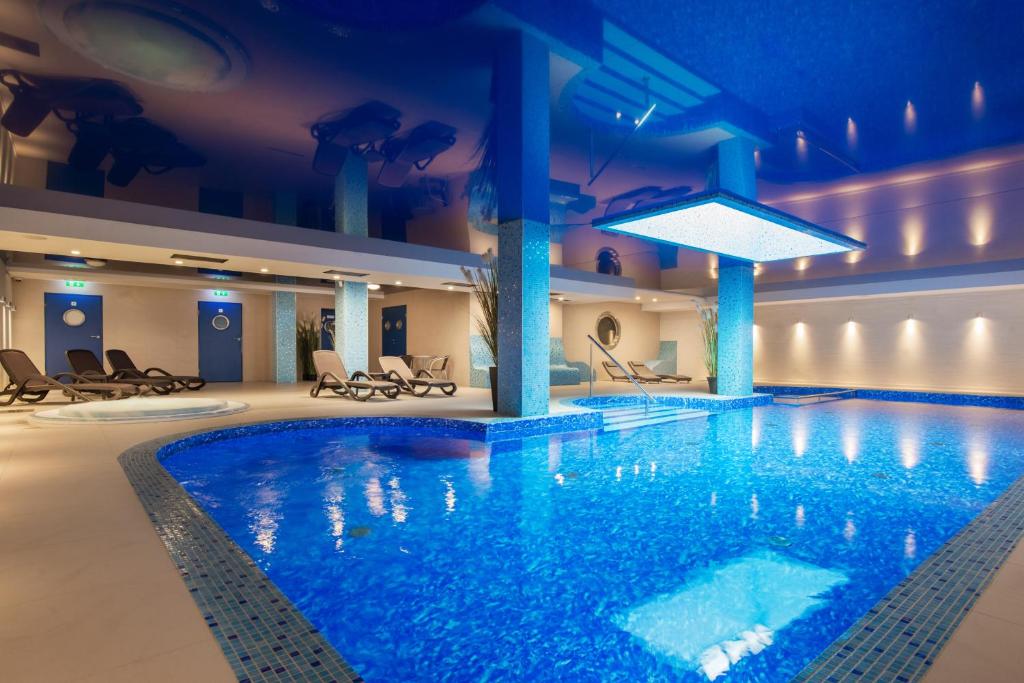 uma grande piscina num hotel com iluminação azul em Hotel Szafir em Jastrzębia Góra