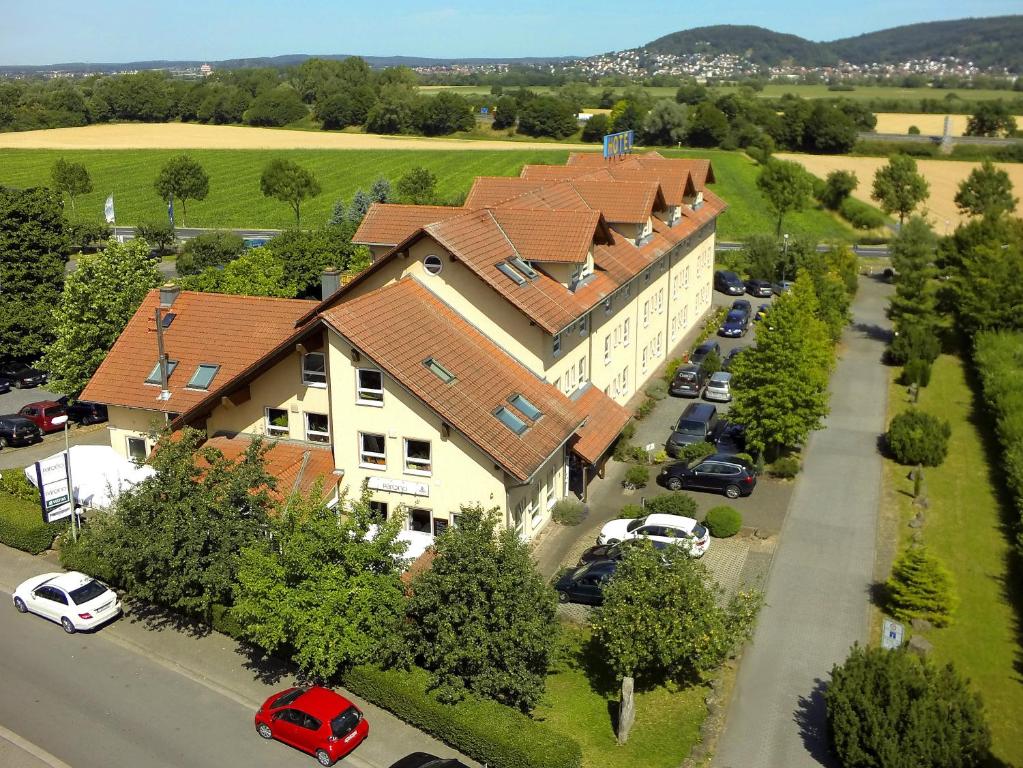 uma vista superior de uma casa grande com um parque de estacionamento em HOTEL PARQÉO im A66 em Gelnhausen