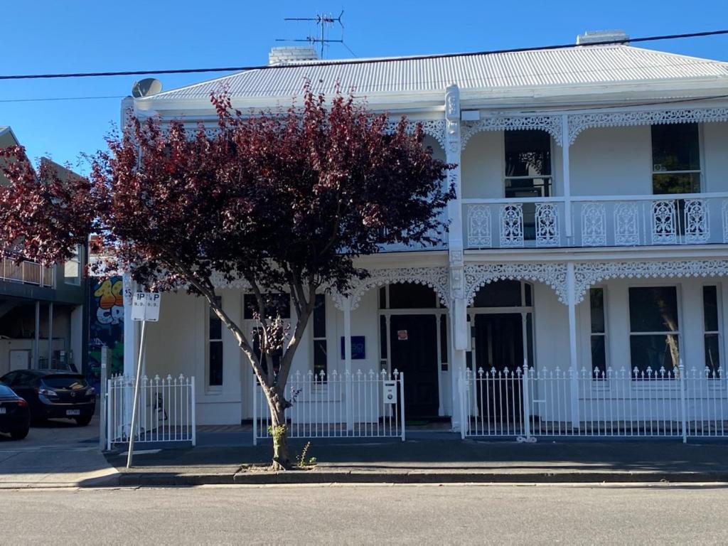 une maison blanche avec un arbre en face dans l'établissement 50 Green St Windsor, à Melbourne