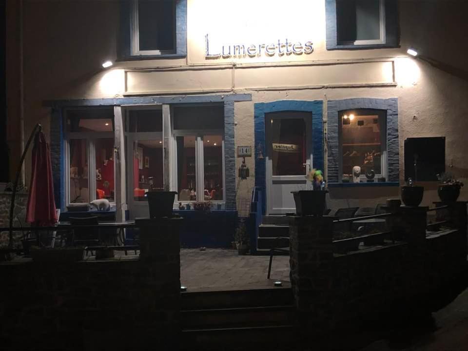 a restaurant with tables and chairs in front of a building at Les Lumerettes - Dohan in Bouillon