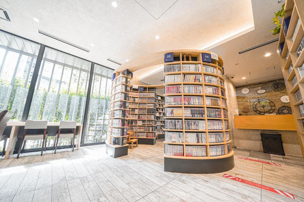 een bibliotheek met een grote hoeveelheid boeken op de planken bij QuintessaHotel TokyoHaneda Comic&Books in Tokyo